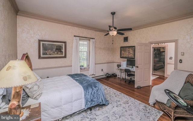 bedroom with baseboard heating, ornamental molding, and wood finished floors