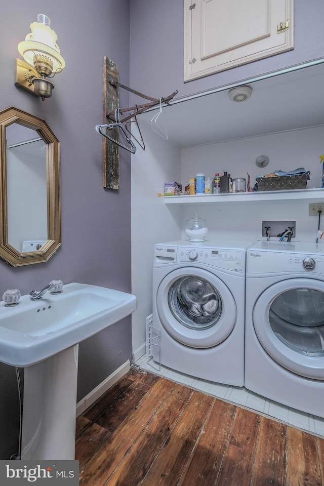 laundry area featuring wood-type flooring, cabinet space, and washing machine and clothes dryer