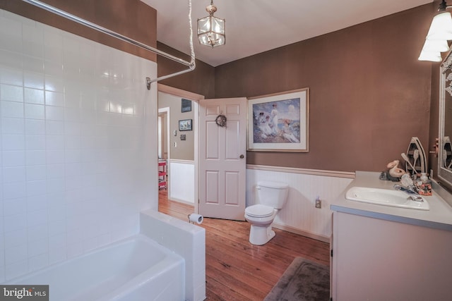 bathroom with vanity, wainscoting, wood finished floors, and toilet