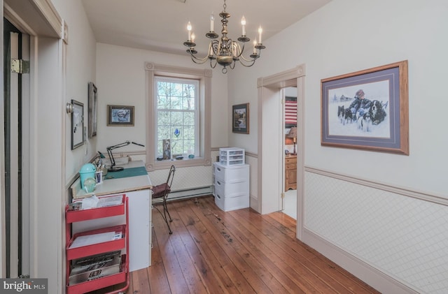 office with an inviting chandelier, a wainscoted wall, a baseboard radiator, and hardwood / wood-style flooring