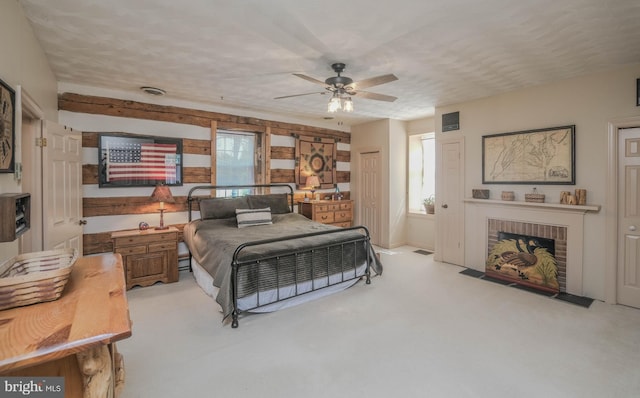 bedroom with ceiling fan, a brick fireplace, and light colored carpet