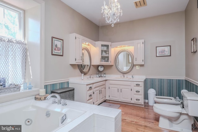 full bathroom with a notable chandelier, a sink, toilet, a whirlpool tub, and visible vents