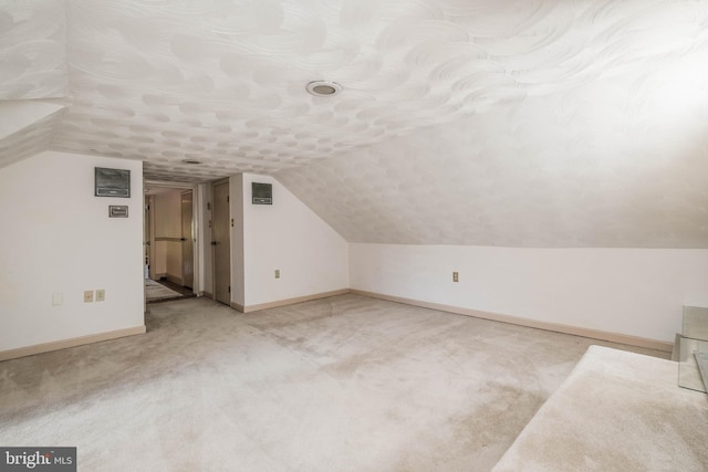 bonus room with carpet floors, baseboards, and vaulted ceiling
