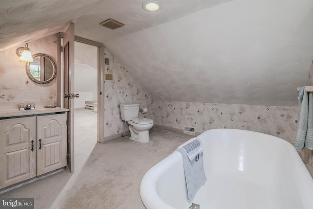 full bathroom with visible vents, a freestanding tub, vaulted ceiling, vanity, and toilet