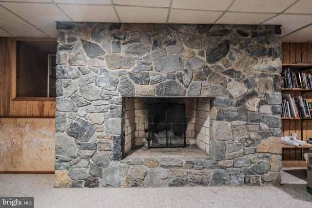 interior details featuring carpet floors, a paneled ceiling, and a fireplace
