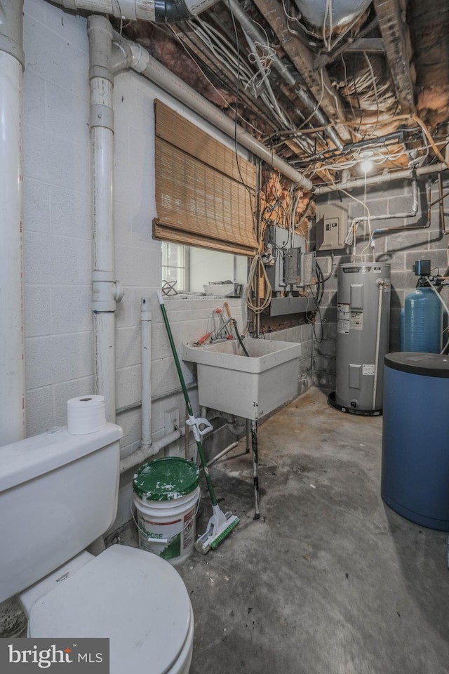 unfinished basement featuring a sink and electric water heater