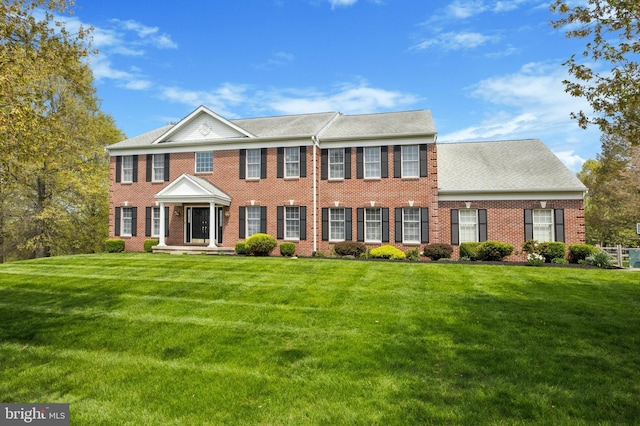 view of front of house with brick siding and a front yard