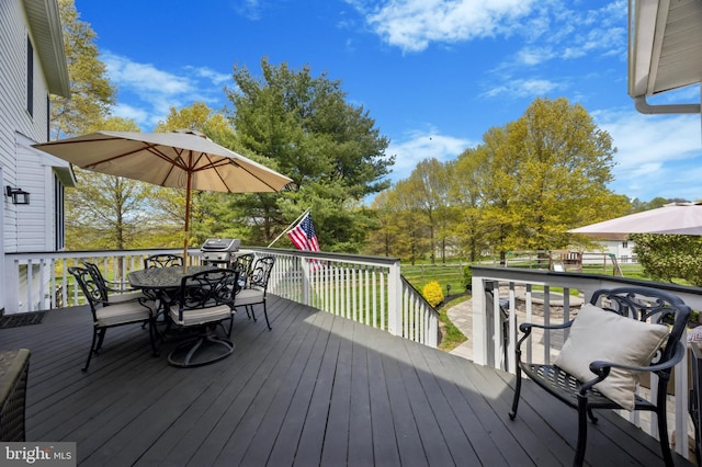 deck featuring outdoor dining space and area for grilling
