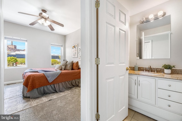 bedroom featuring a sink, ceiling fan, and light carpet