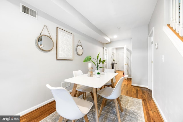 dining room with baseboards, visible vents, and wood finished floors