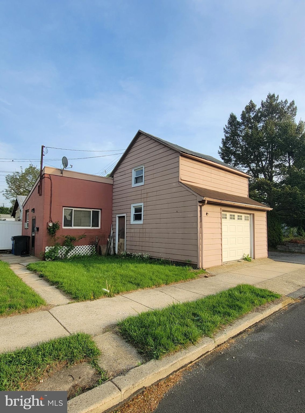 view of side of home with a lawn, driveway, and a garage