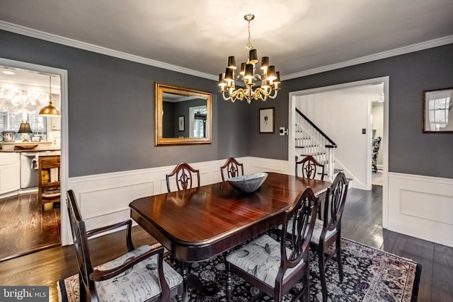 dining space featuring ornamental molding, dark wood-style flooring, wainscoting, stairway, and a chandelier