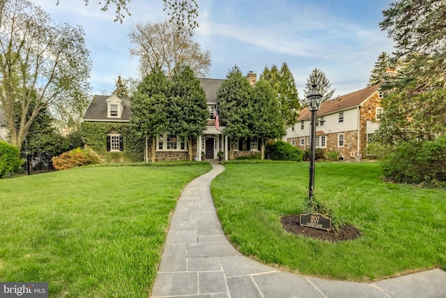 view of front of home featuring a shingled roof and a front yard