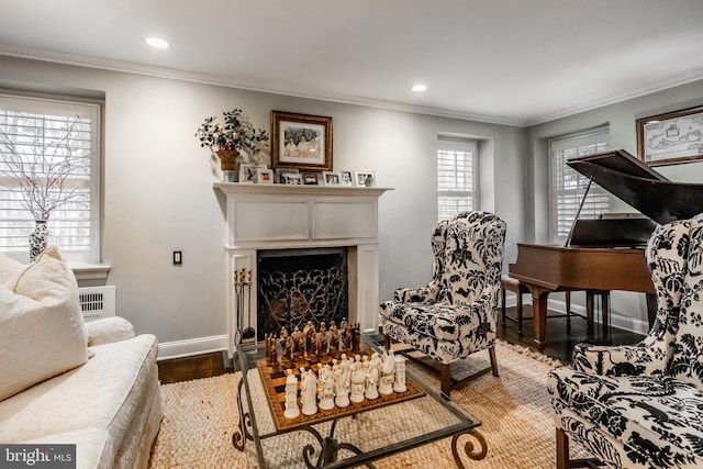 living area featuring a fireplace, wood finished floors, baseboards, ornamental molding, and recessed lighting