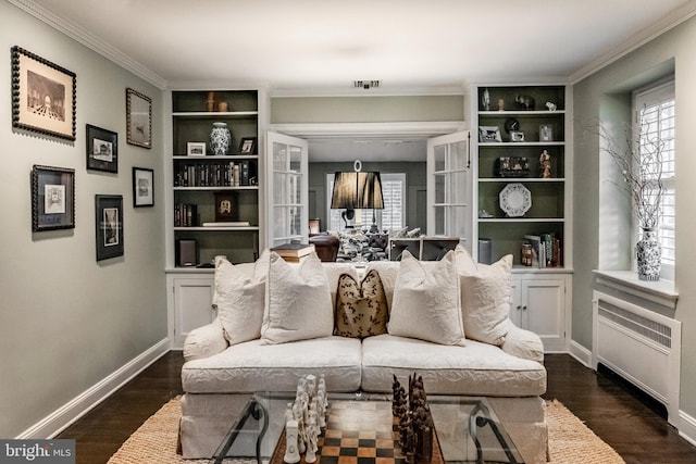 living room with crown molding, built in features, a healthy amount of sunlight, and dark wood-type flooring