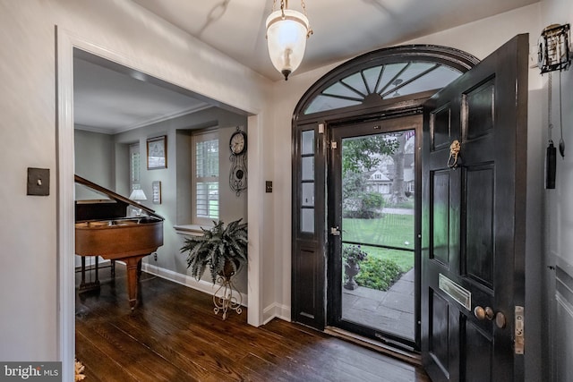 entryway featuring a healthy amount of sunlight, baseboards, ornamental molding, and dark wood finished floors