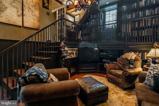 interior space with stairs, a high ceiling, an inviting chandelier, and wood finished floors