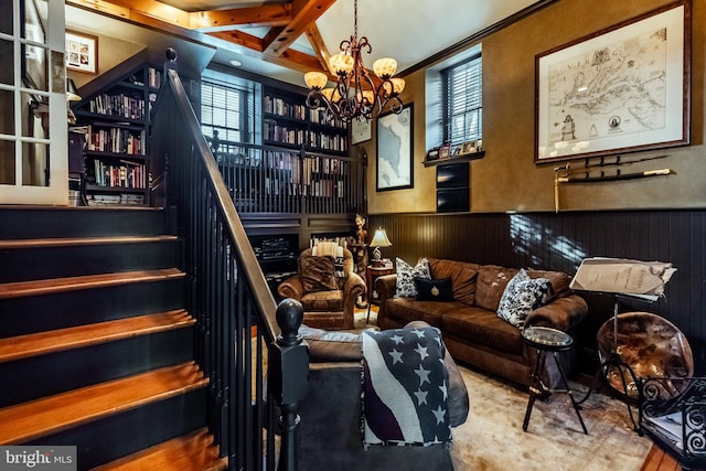 interior space with wooden walls, a notable chandelier, wainscoting, and a healthy amount of sunlight