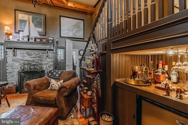 bar featuring a towering ceiling, a fireplace, wet bar, and wood finished floors