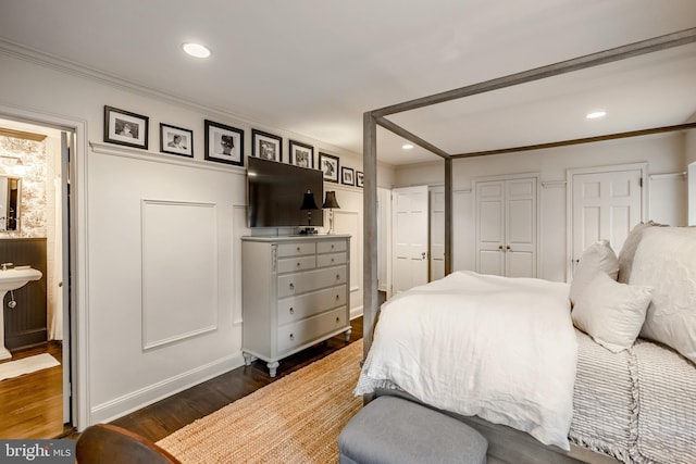 bedroom featuring crown molding, ensuite bath, recessed lighting, baseboards, and dark wood-style floors