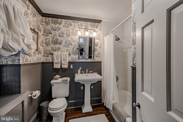 full bath featuring wood finished floors, shower / bath combination with curtain, toilet, wallpapered walls, and a wainscoted wall