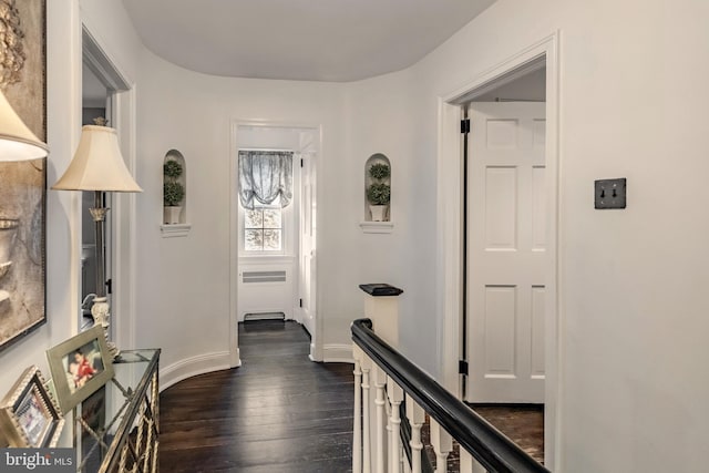 hallway with baseboards, dark wood-style floors, and radiator