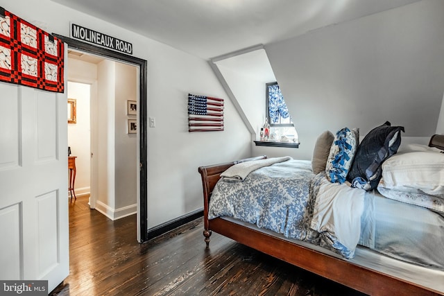 bedroom with wood-type flooring and baseboards