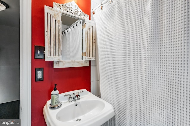full bath featuring a sink and a shower with shower curtain