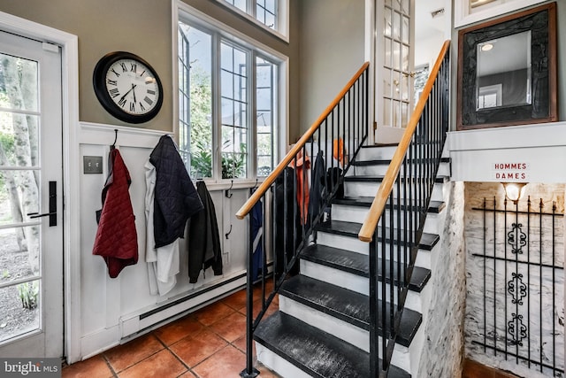stairway with tile patterned flooring, baseboard heating, and visible vents