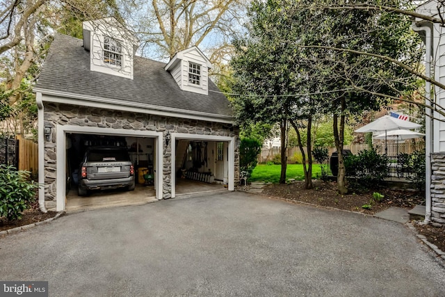 garage featuring fence and driveway