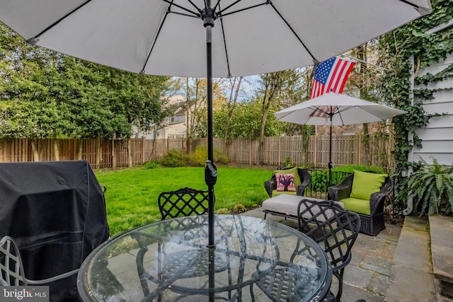 view of patio with area for grilling, fence, and outdoor dining space