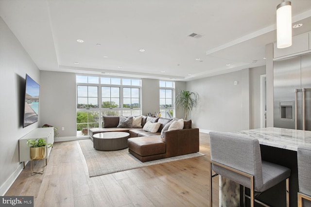 living area with recessed lighting, baseboards, visible vents, and light wood-style floors