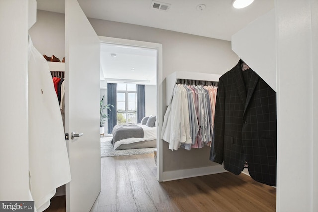 walk in closet with wood finished floors and visible vents