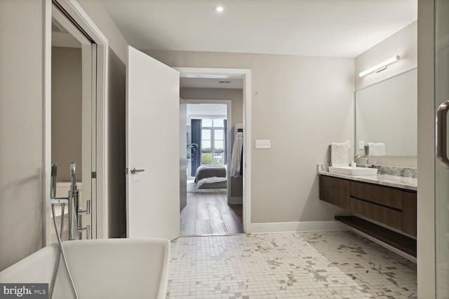 ensuite bathroom featuring baseboards, ensuite bath, tile patterned floors, and vanity