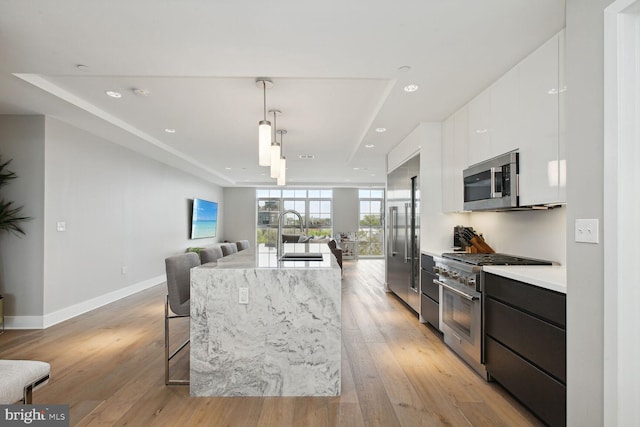 kitchen with modern cabinets, a sink, light countertops, white cabinets, and stainless steel appliances