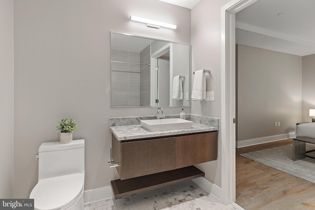 full bath with baseboards, wood finished floors, toilet, and vanity