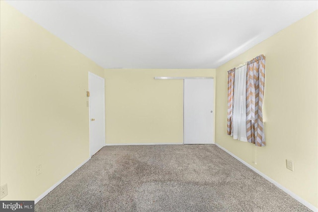 empty room with carpet floors and baseboards