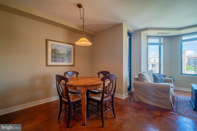 dining area with concrete flooring, baseboards, and visible vents