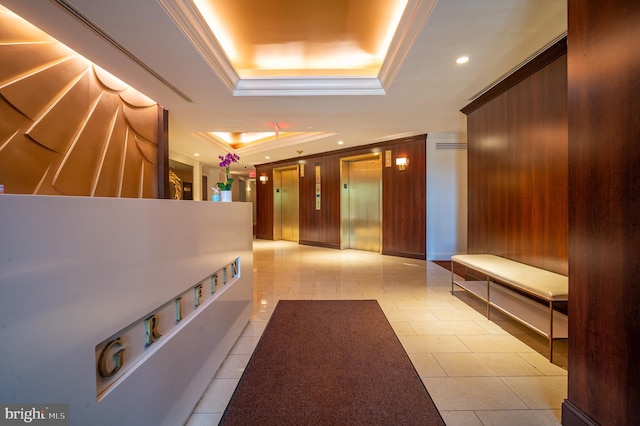 hall with recessed lighting, elevator, ornamental molding, and a raised ceiling