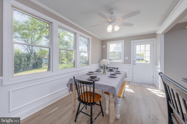 dining space with crown molding, light wood finished floors, and a wealth of natural light