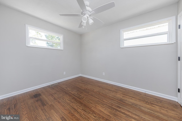 unfurnished room featuring baseboards, ceiling fan, dark wood-style flooring, and visible vents