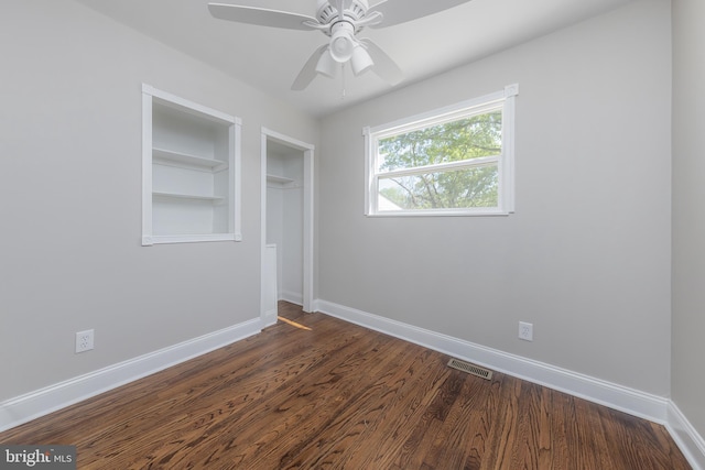 unfurnished bedroom with baseboards, a closet, dark wood-type flooring, and visible vents