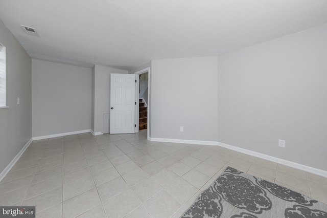 unfurnished room featuring stairs, light tile patterned flooring, baseboards, and visible vents