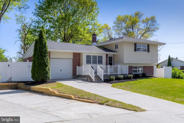 split level home with brick siding, a garage, a front lawn, and a chimney