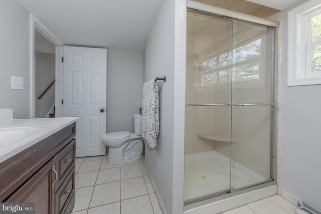 bathroom with toilet, tile patterned floors, and a shower stall