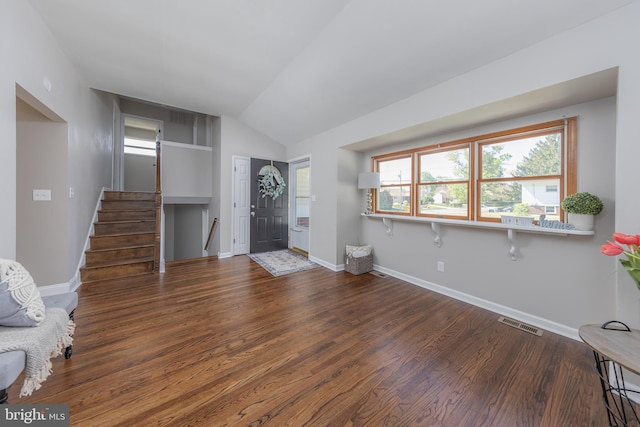 interior space featuring visible vents, stairs, wood finished floors, and lofted ceiling