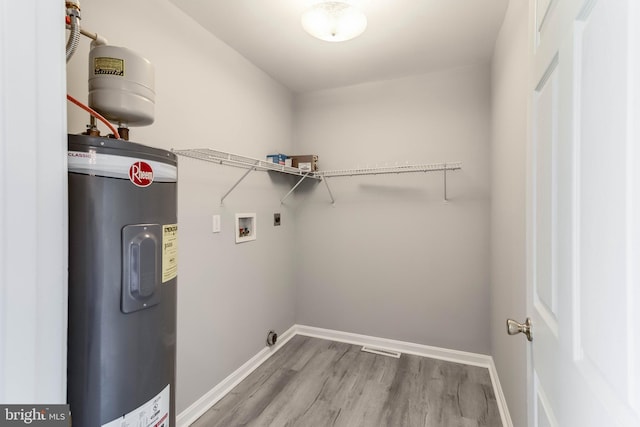laundry room with hookup for an electric dryer, laundry area, baseboards, hookup for a washing machine, and water heater