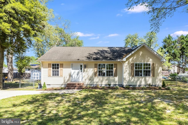 single story home featuring fence, a shed, a front yard, crawl space, and an outbuilding