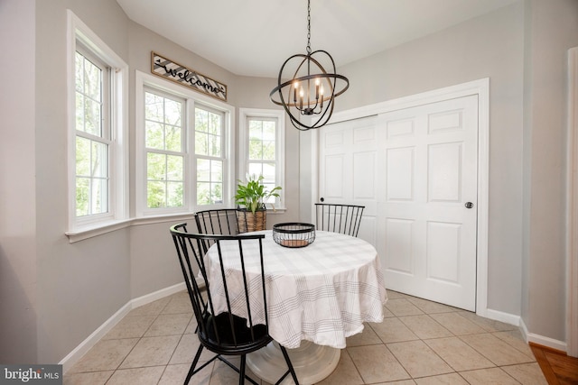 dining area with an inviting chandelier, baseboards, and light tile patterned flooring
