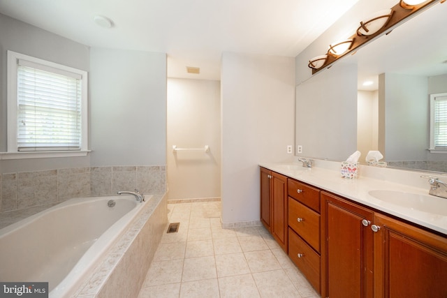 full bath featuring a sink, double vanity, a bath, and tile patterned floors